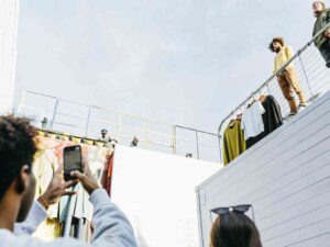 People photographing fashion display on rooftop setup.