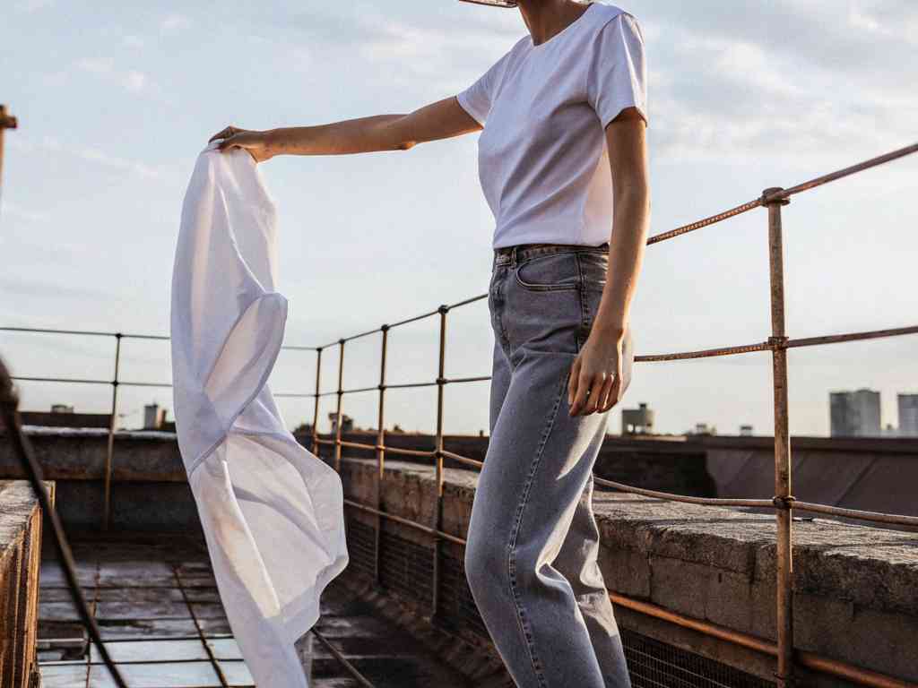 Casual white tee and jeans style at sunset rooftop