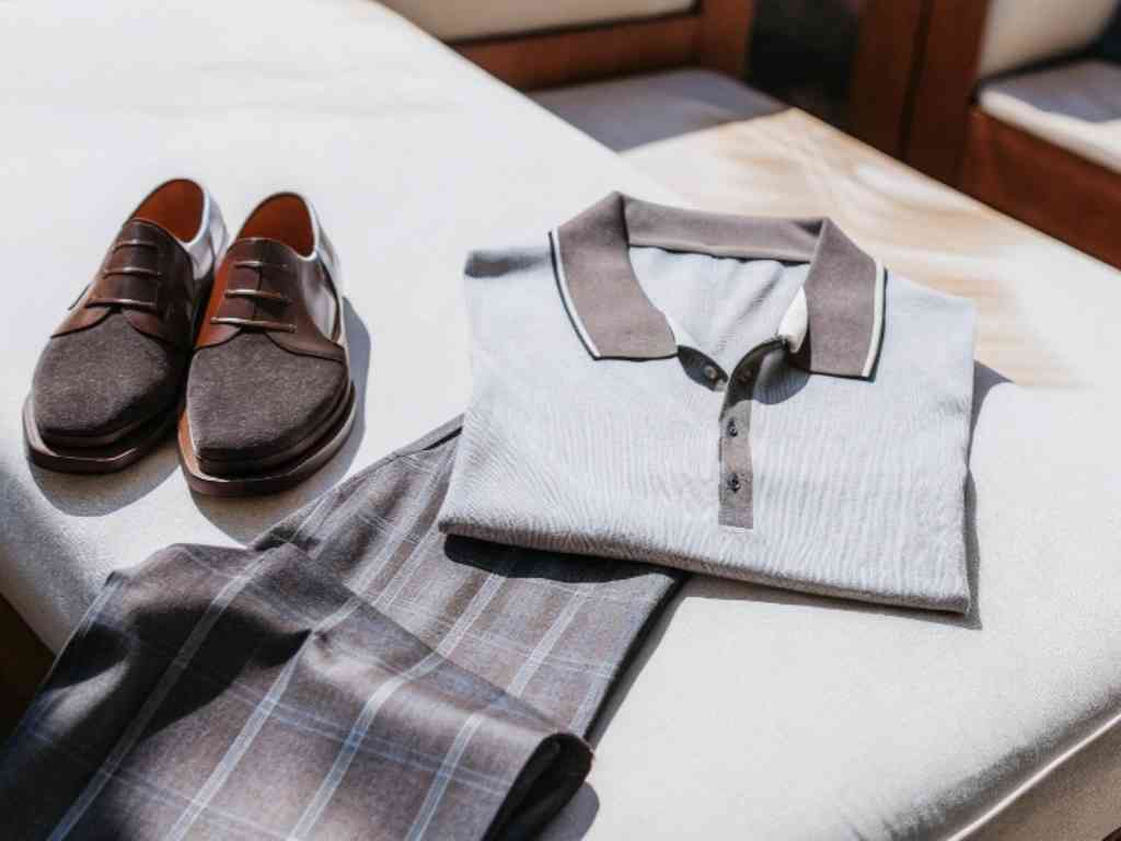 Flat lay of gray polo shirt with brown shoes and plaid pants