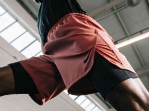 Athlete in red Nike shorts and black compression tights during an intense workout in a modern gym.