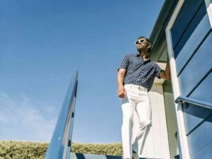 Man in printed shirt and white pants under blue sky