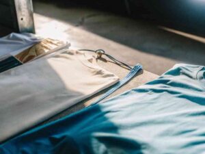 Blue and cream t-shirts displayed on table in sunlight