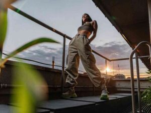 Woman in jogger-style cargo pants at sunset rooftop