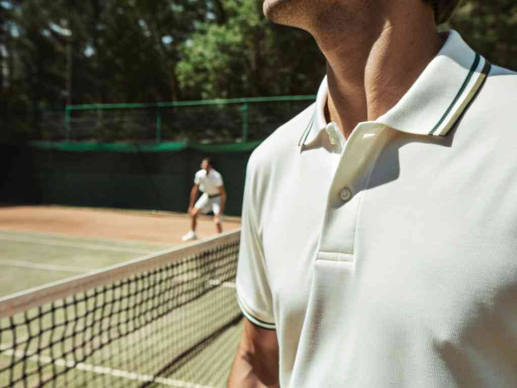 Close-up of man in white polo shirt on tennis court