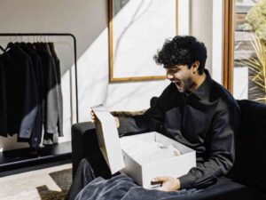 Man joyfully opening white box in bright modern room