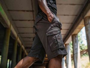 Close-up of man wearing dark cargo shorts in industrial setting