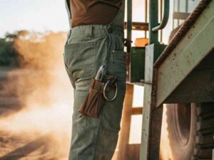 Close-up of green utility pants with tools on a construction site