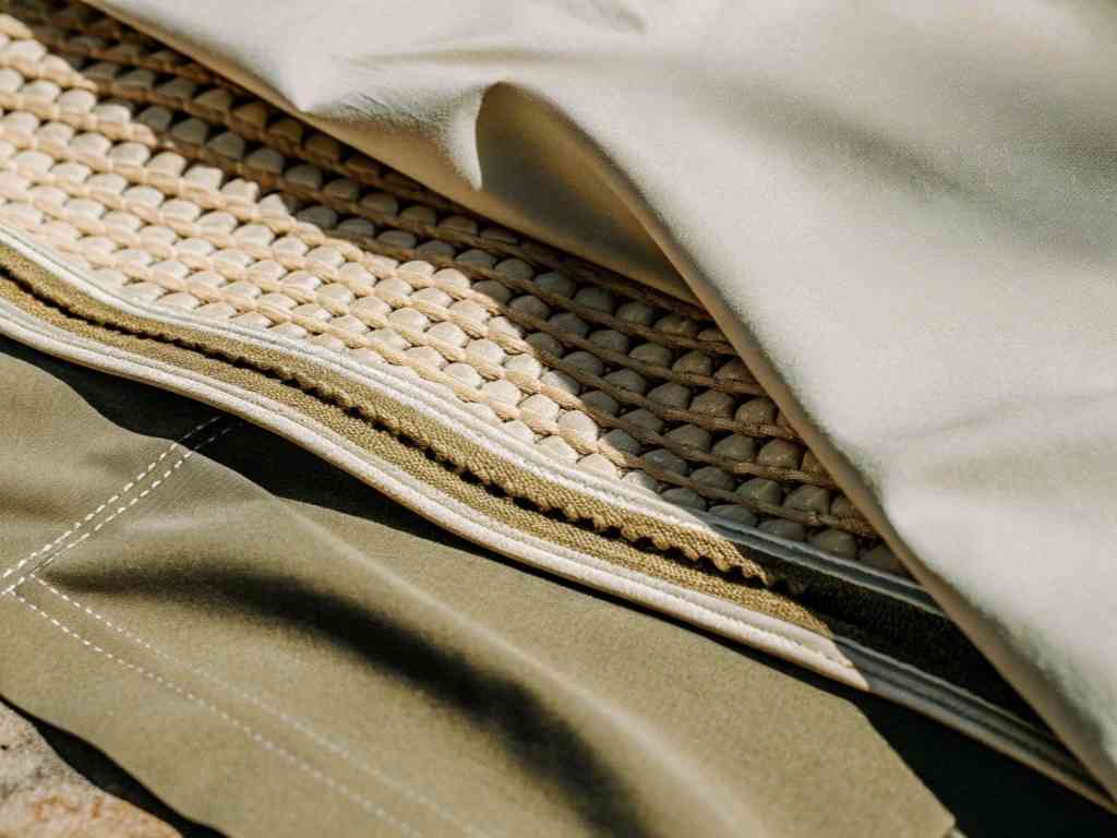 Layered technical fabric materials showing padding, stitching, and lining.