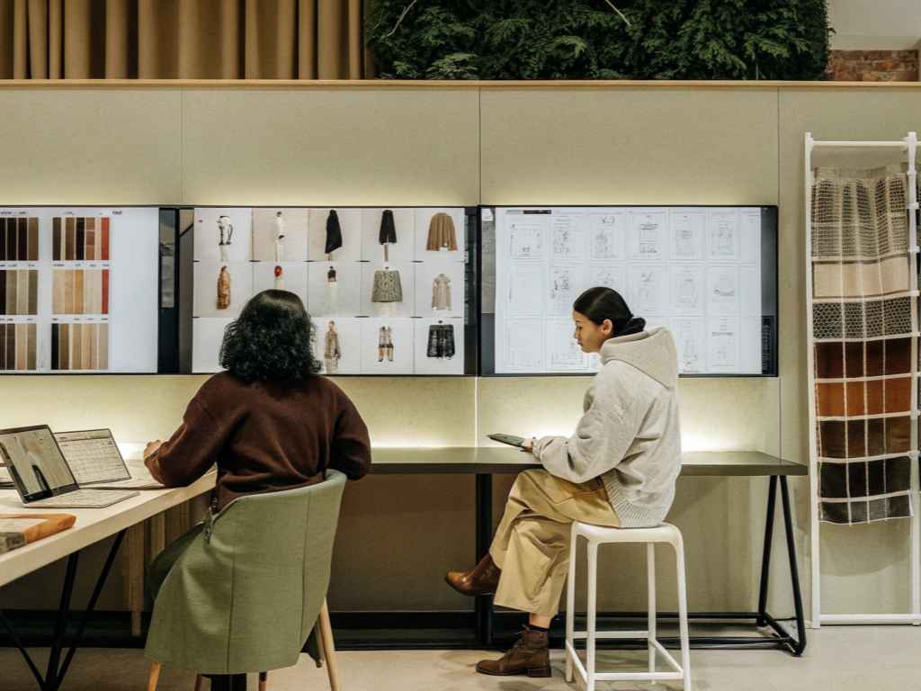Fashion designers reviewing fabric swatches and concept boards in modern workspace