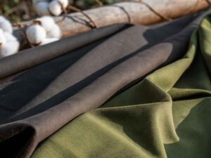 Black and olive green cotton fabrics laid out with cotton stems.