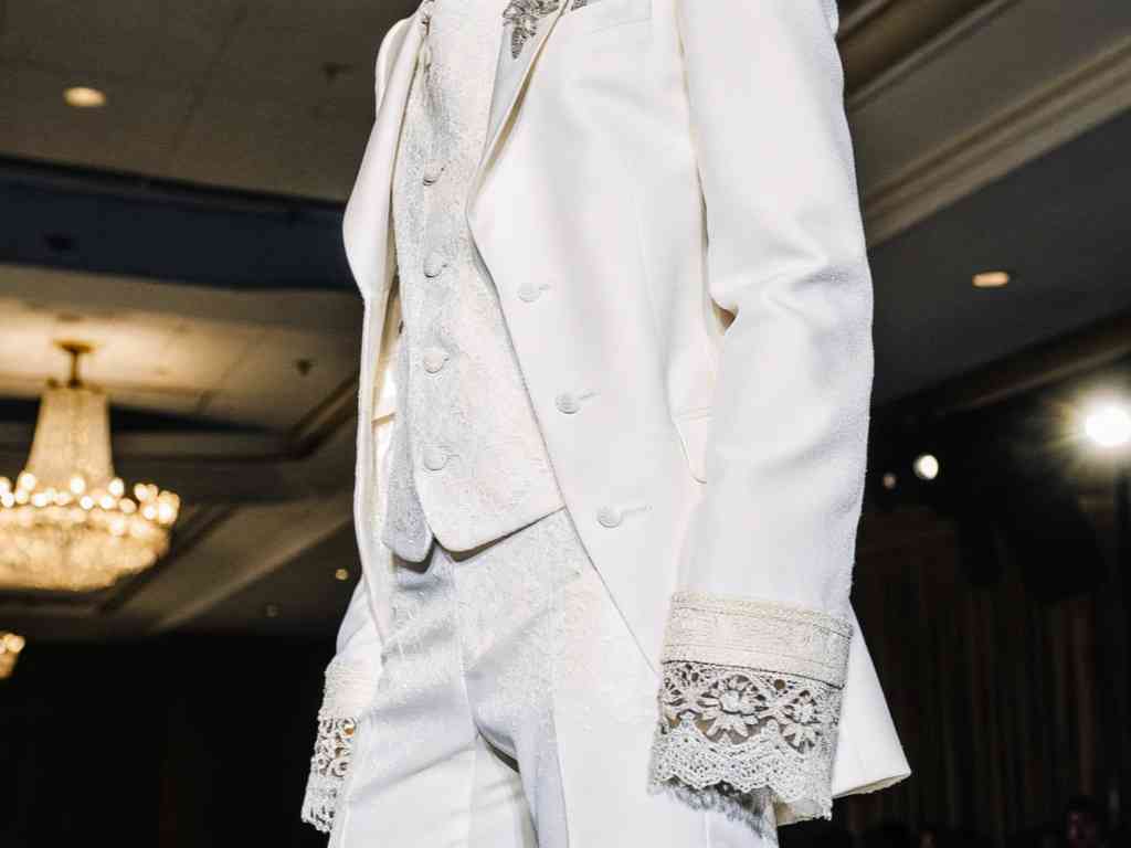 Close-up of white suit with lace details on cuffs