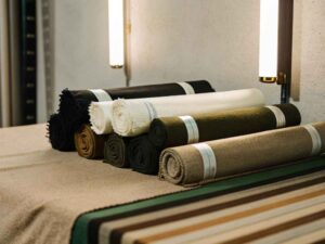 Rolled textile fabrics in neutral and earthy tones arranged on showroom table