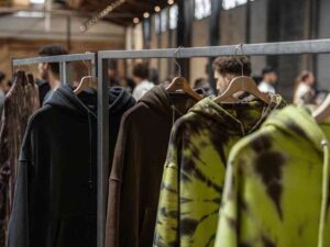 Tie-dye and solid color hoodies on display at urban fashion pop-up.