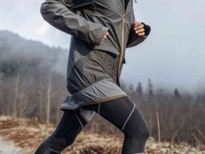 Trail runner in dark activewear moving through foggy forest terrain