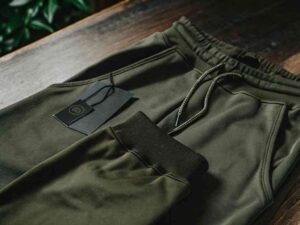 Close-up of folded olive green joggers with premium hang tag