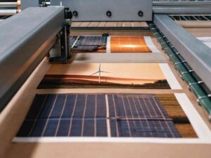 Large-format printer creating images on solar panels and wind turbines