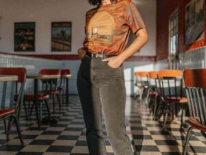 Woman wearing retro graphic t-shirt and jeans in vintage diner