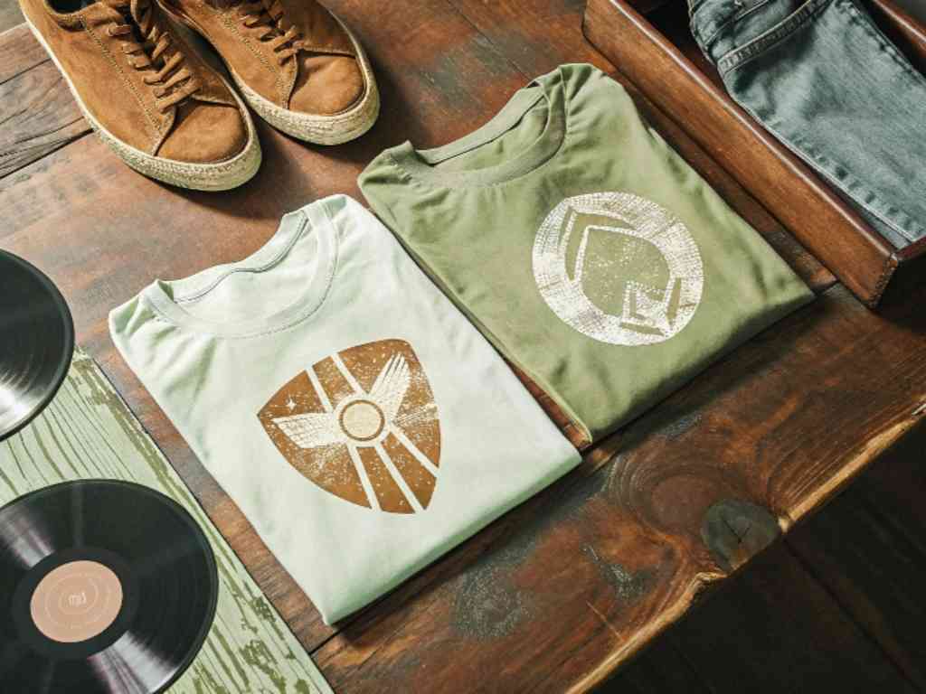 Two folded vintage t-shirts with distressed logos on wooden surface