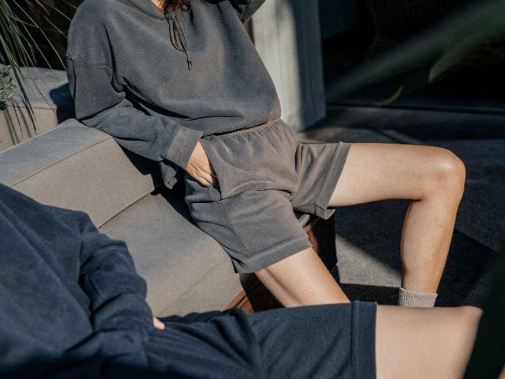 Woman in earth-tone fleece lounge set with sweatshirt and shorts on patio