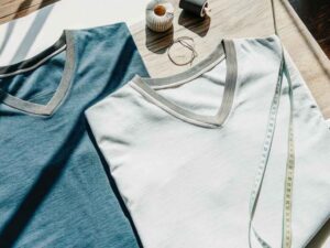 Blue and white v-neck t-shirts styled with sewing accessories.