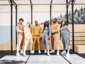 Diverse group in neutral-toned activewear posing in gym studio