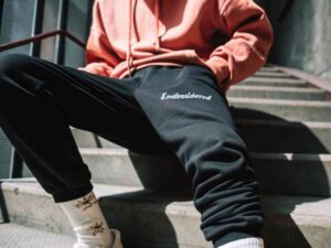Streetwear outfit with black joggers featuring white embroidered text