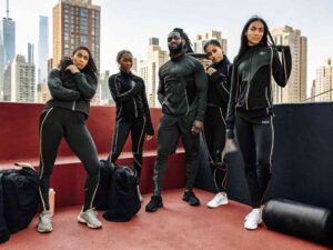 Group of athletes in black custom sportswear posing on urban rooftop