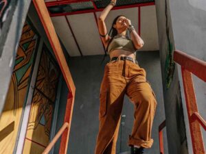 Woman in brown cargo pants and green crop top on stairs