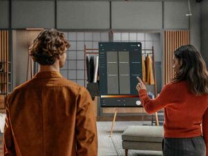 Woman using a digital interface to browse fashion options beside a man.