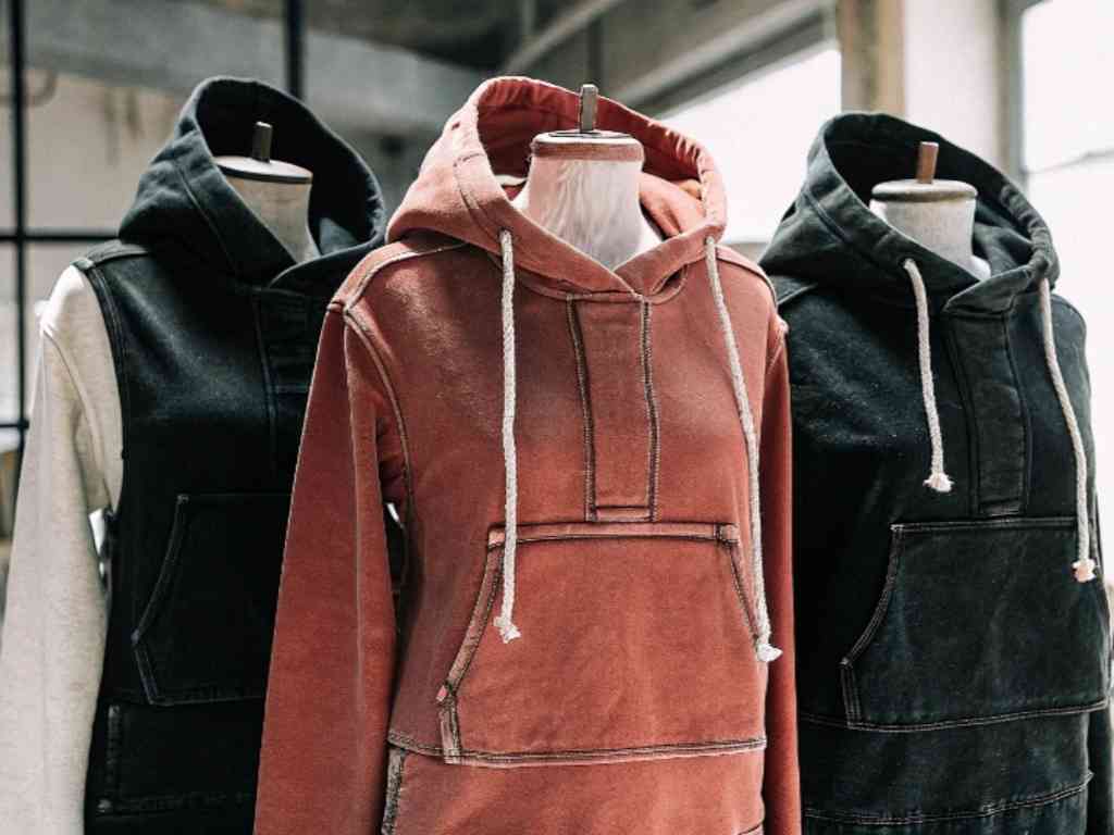 Three washed hoodies on dress forms in studio setting.