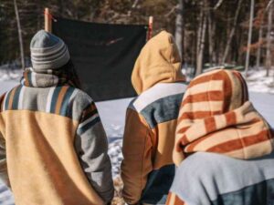 Group in striped fleece hoodies standing in snowy forest