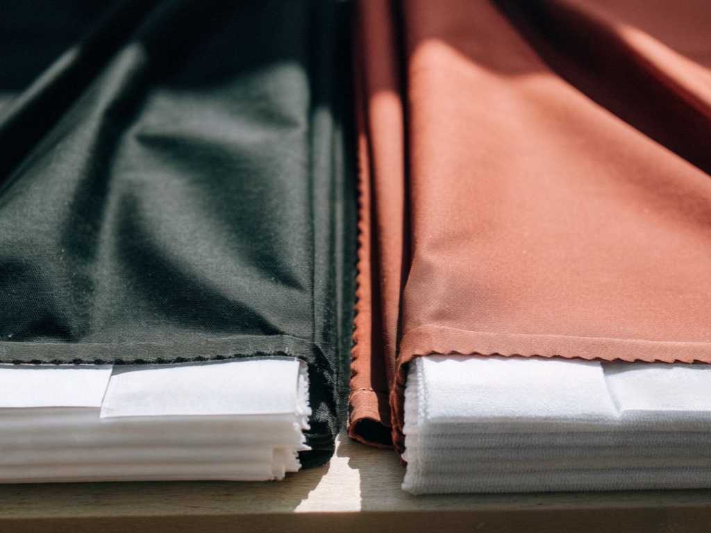 Folded black and rust-colored fabric stacks placed on table.
