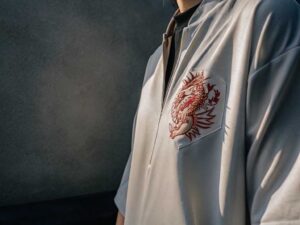 Gray zip-up jacket with embroidered red dragon design