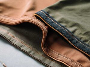 Macro of double-stitched canvas hems in earthy brown and green