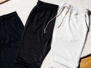 Black, charcoal and white sweatpants arranged neatly for fabric contrast
