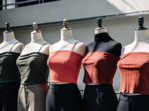 Row of mannequins modeling ribbed tank and crop tops outdoors