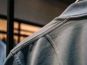 Macro of reinforced shoulder seam and rib collar on slate T-shirt