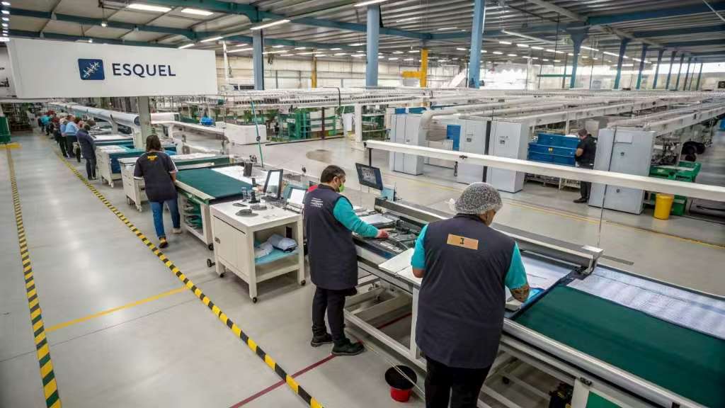 Workers inspecting and preparing fabrics at Esquel factory