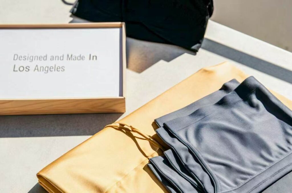 Folded activewear beside box labeled "Designed in Los Angeles".