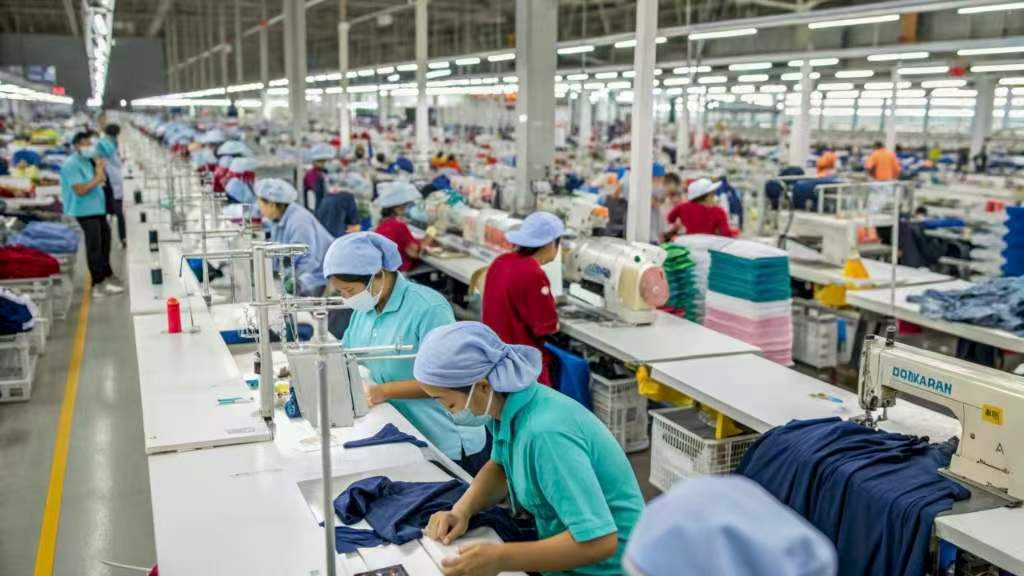 Workers in a large garment factory sewing clothes