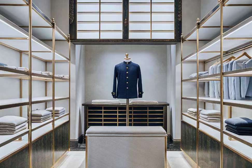 Tailored navy jacket on mannequin in modern luxury boutique.