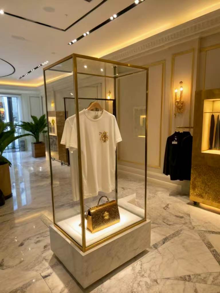 luxury boutique display with t-shirt and gold handbag